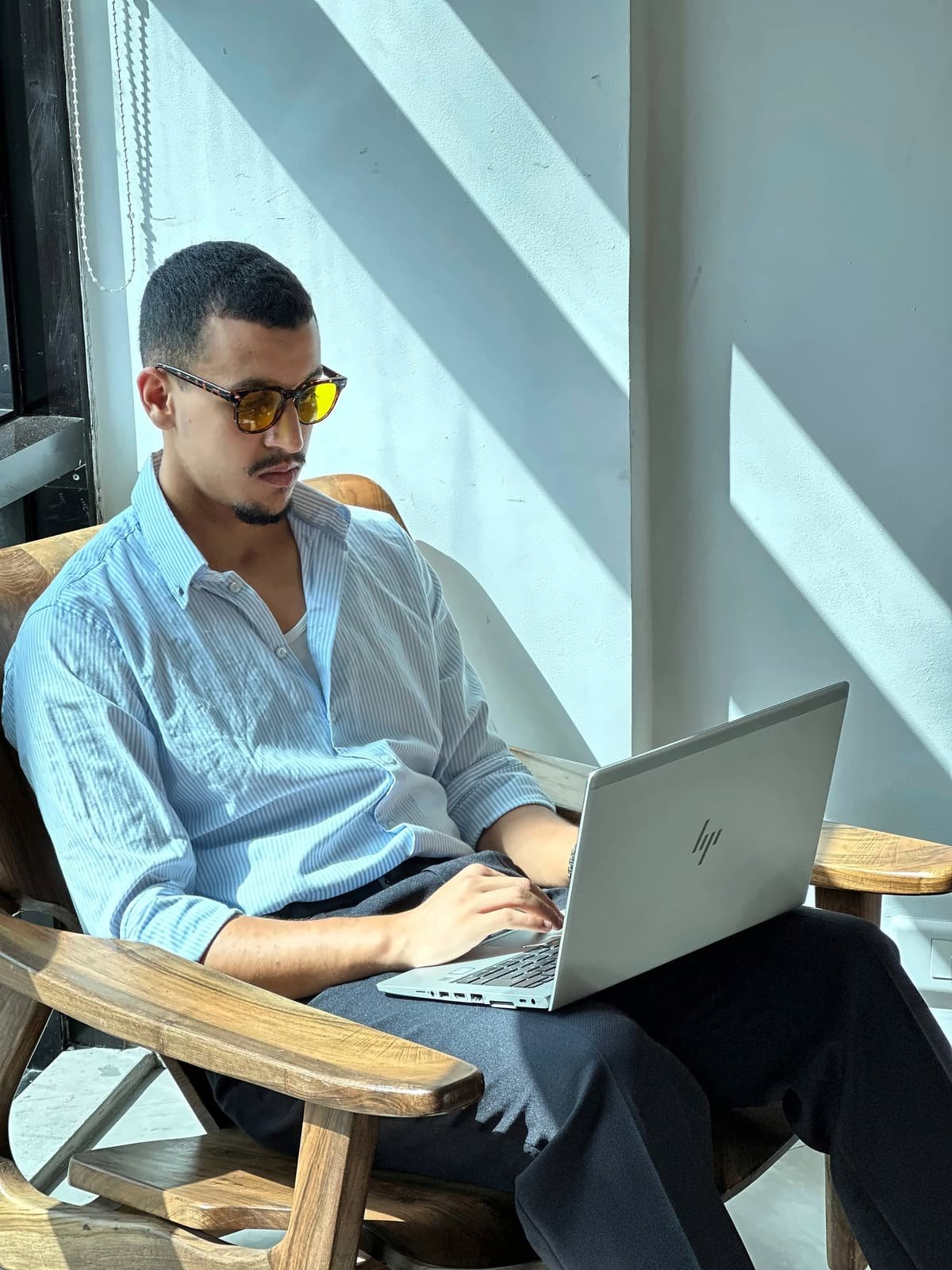 Homme travaillant sur son ordinateur portable au soleil avec des lunettes Bleuvex Ambris aux verres jaunes