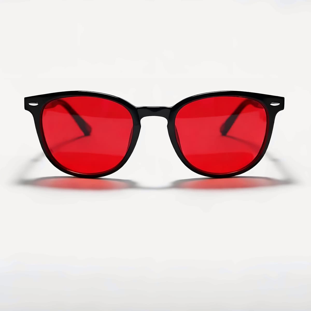 Lunettes Bleuvex Noctis, monture noire et verres rouges, vues de face sur fond crème