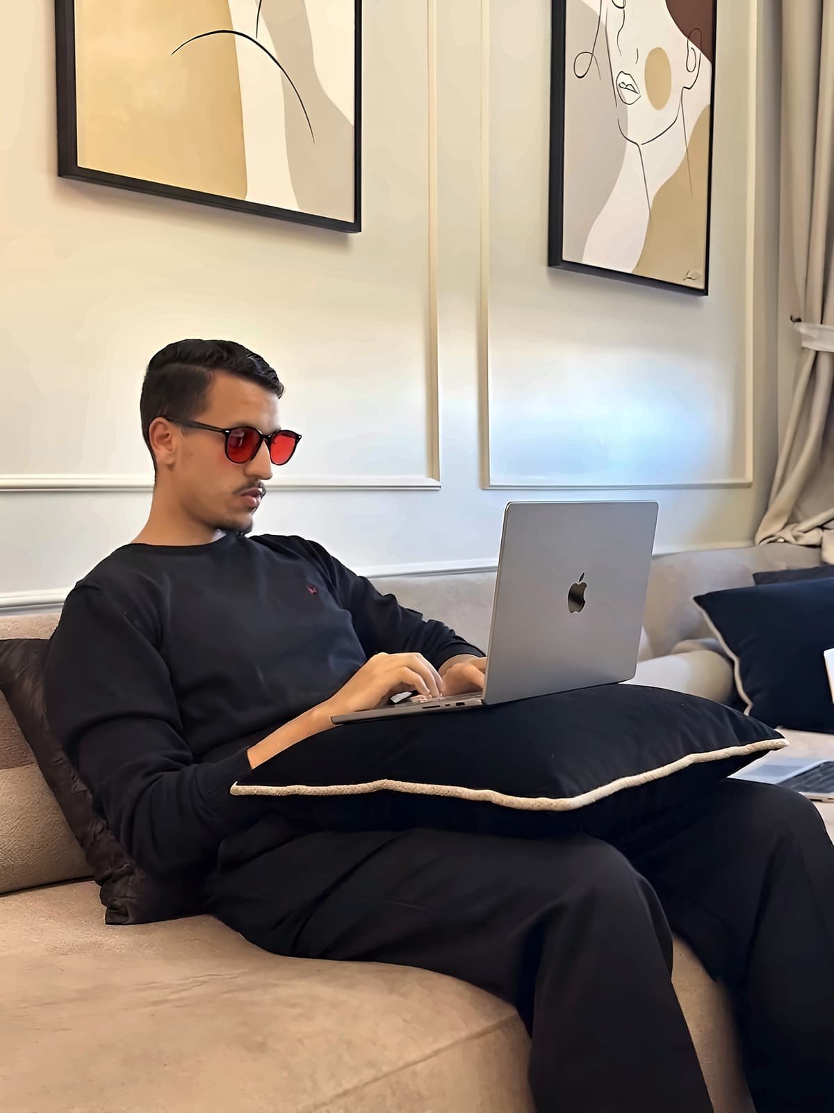 Homme sur un canapé le soir avec son ordinateur portable, portant des lunettes Bleuvex Noctis aux verres rouges