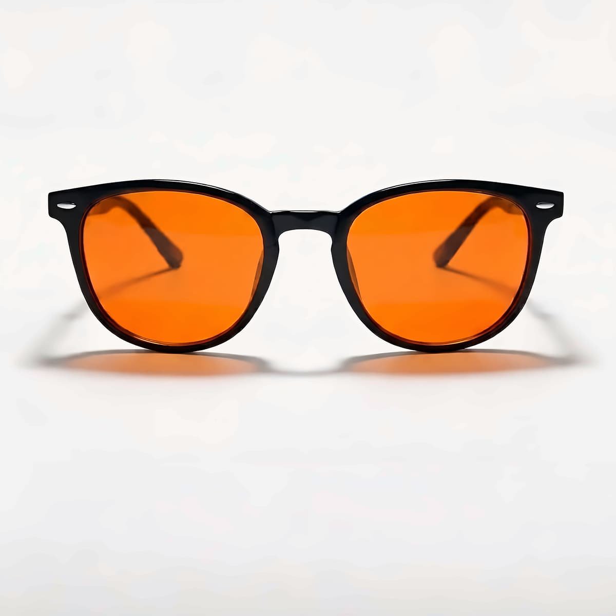 Lunettes Bleuvex Solaris, monture noire et verres orange, vues de face sur fond crème